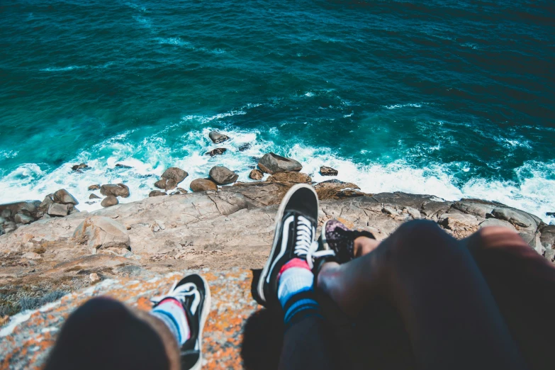 feet in sneakers looking out over the ocean
