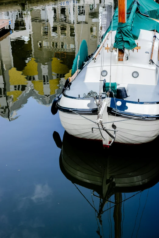 the sailboat is moored in a dock with buildings in the background