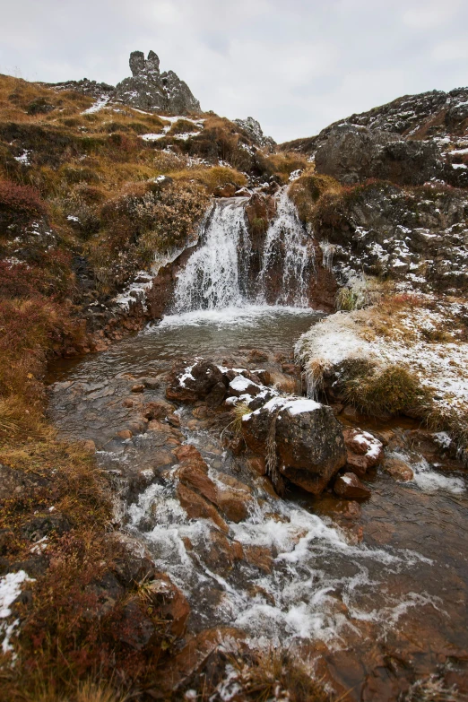 a small waterfall is on top of the mountain