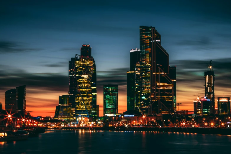 a city night view and the lights on, all lit up and reflecting off water