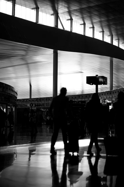 a couple of people walk through an airport