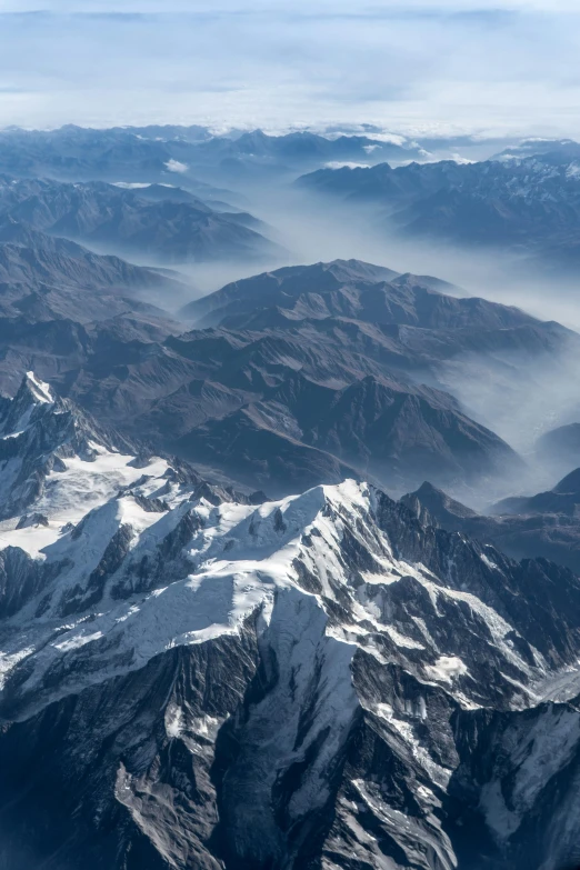 there is snow on the mountain and fog coming in from the clouds