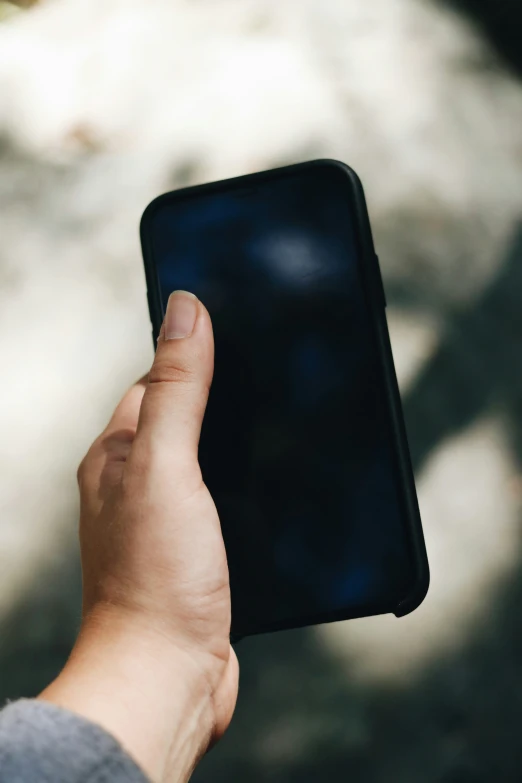 a hand holding onto an appliance while outdoors