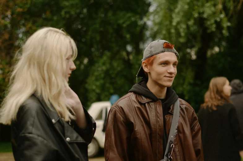 two young people with hair in pony pomp and a beanie on