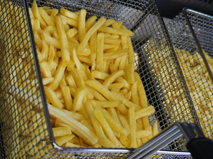 french fries in silver strainers with a black lid