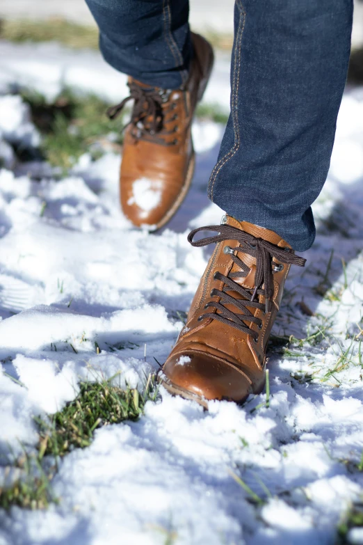 the man is wearing brown shoes on the snow