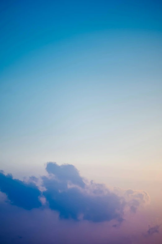 the sky is blue with white clouds at dusk