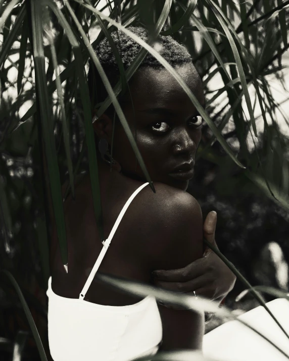 a woman standing in front of a jungle filled with plants