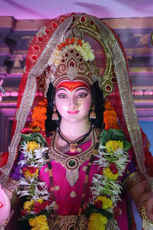 a statue of an indian woman dressed in makeup and accessories