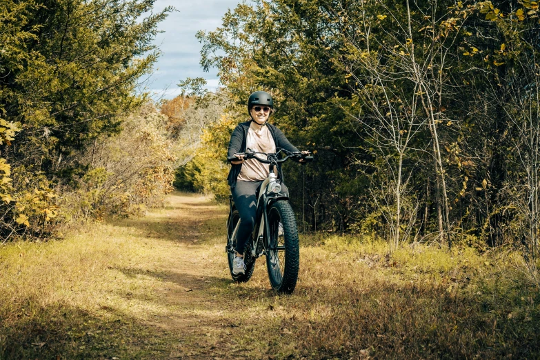 a  riding her bike in a trail