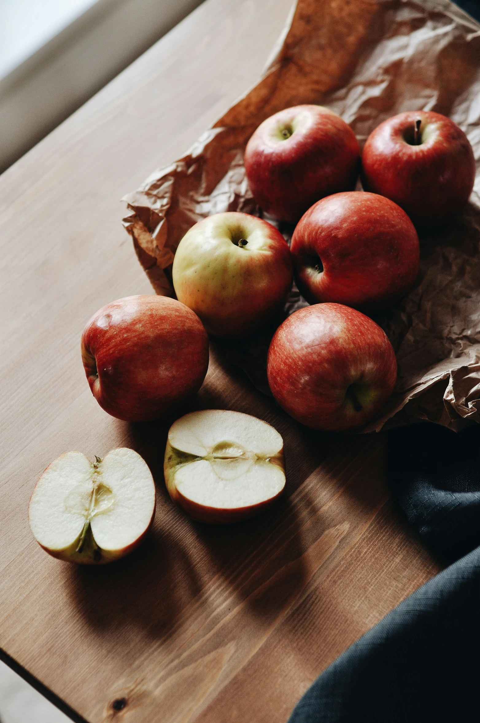 apples on a brown paper bag sitting on a table