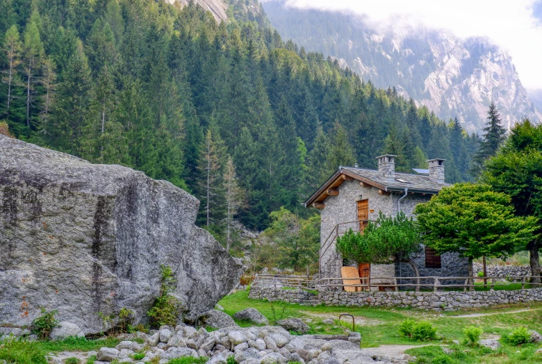 a stone building sitting near a mountain side