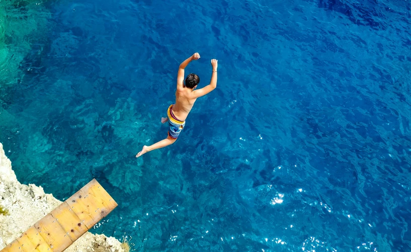 a man in the water swimming near a dock