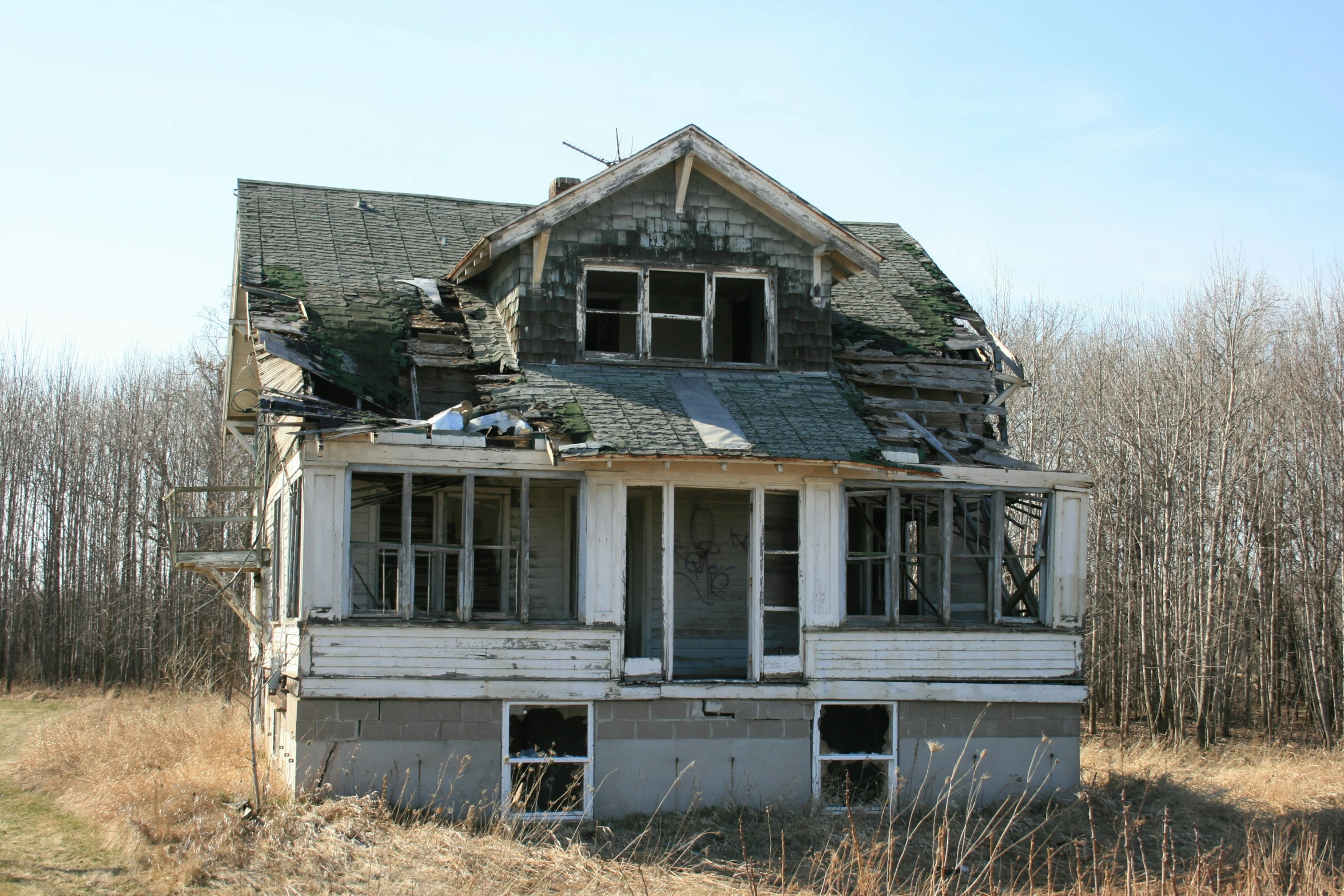 an old run down house has broken windows