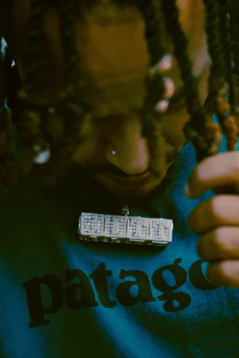 a woman wearing dreadlocks is holding a remote control