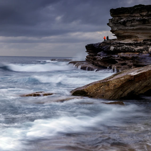 a person standing on rocks overlooking an ocean