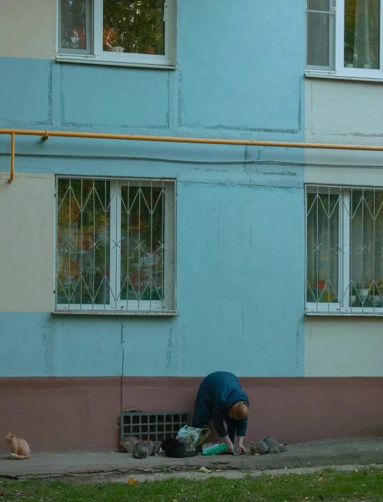 a person bending over near a building