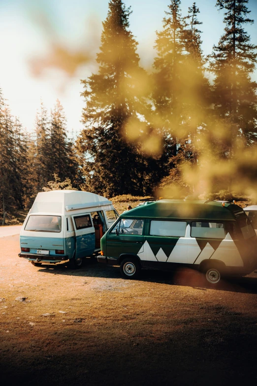 a couple of vans parked next to each other in the middle of the forest