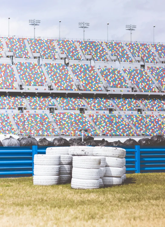 several white cups sit in a row on a stadium bench