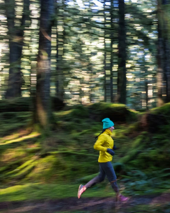 a man in yellow jacket running in the woods