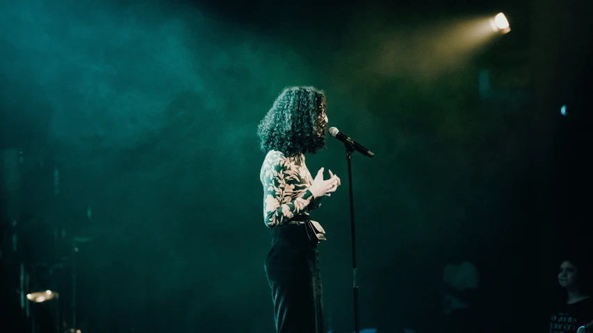 a woman standing on stage with a microphone