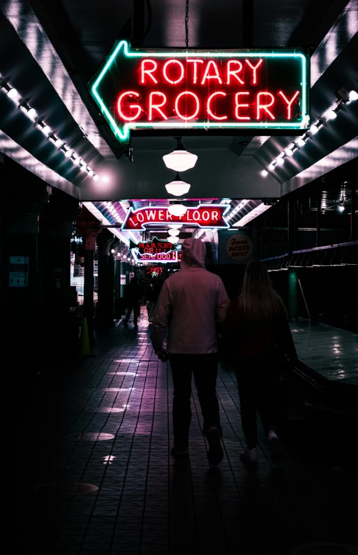 two people walking down the walkway at rotary grocery