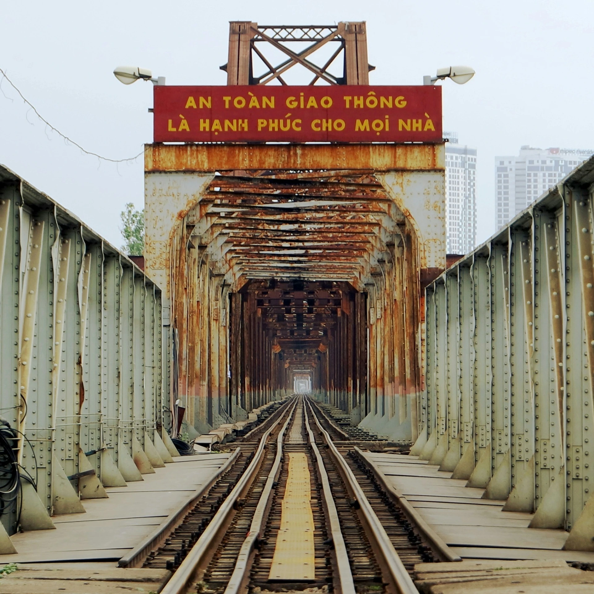 an old rusted bridge with train tracks and the man standing on the top