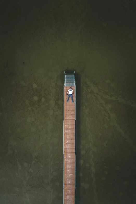 a man walking down the wooden pier