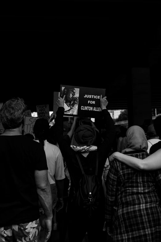 a black and white po of a protest with the words justice written in human language