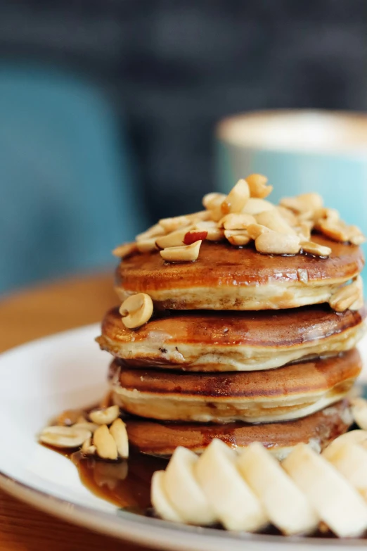 a stack of pancakes covered in nuts on a plate