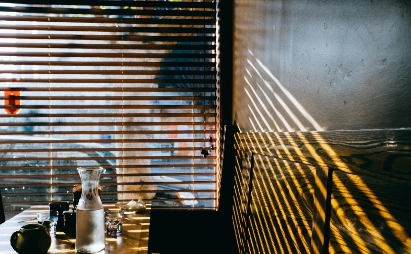 the windows with blinds are behind the table