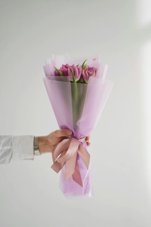 someone holding flowers up with one hand