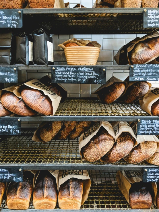 the bakery shelf contains bread and pastries in baskets