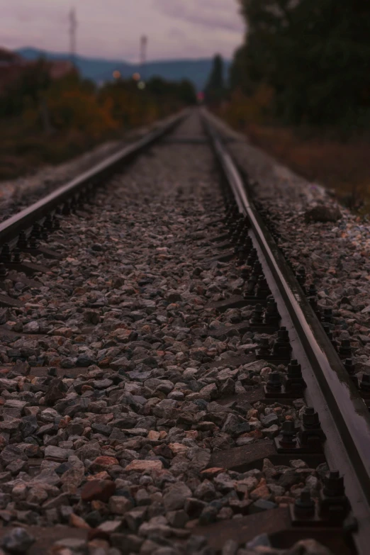 a long dark train track with rocks in the foreground