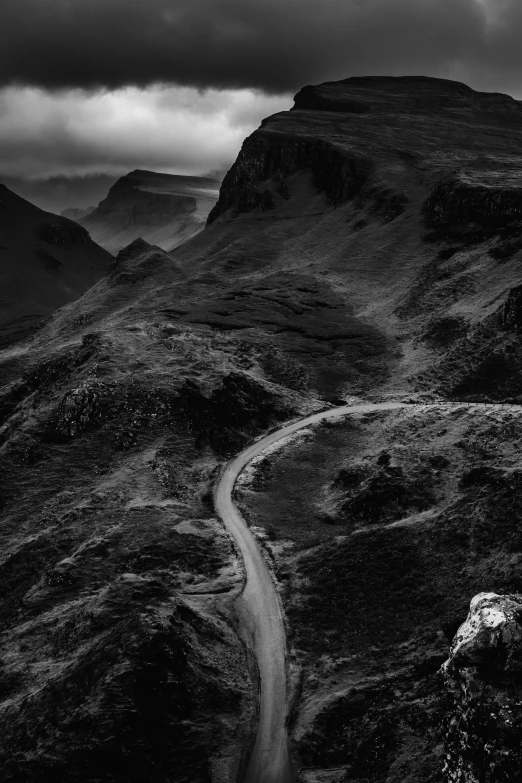 a winding road on a dark mountainside in the scottish