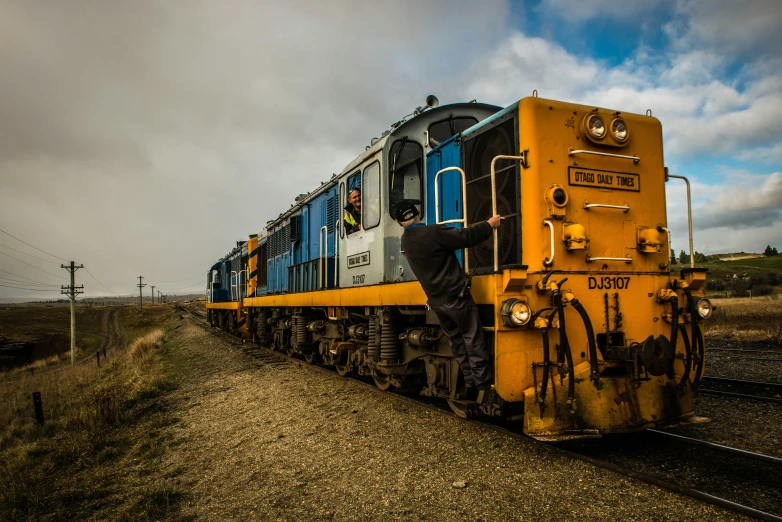 a train that is on the tracks in a field