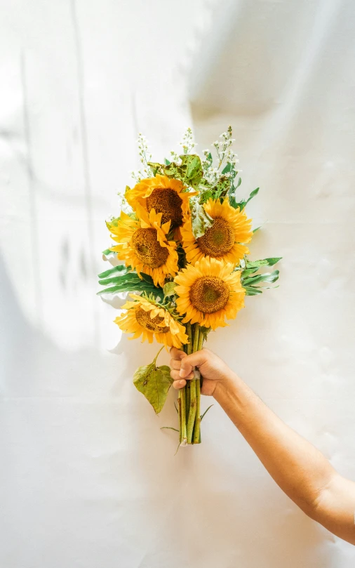 a person holding sunflowers in their hand