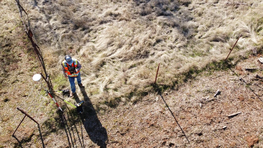 an aerial view of a man standing in the grass