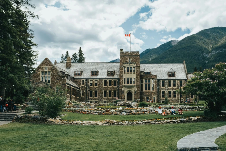 a large stone building surrounded by trees on top of a field