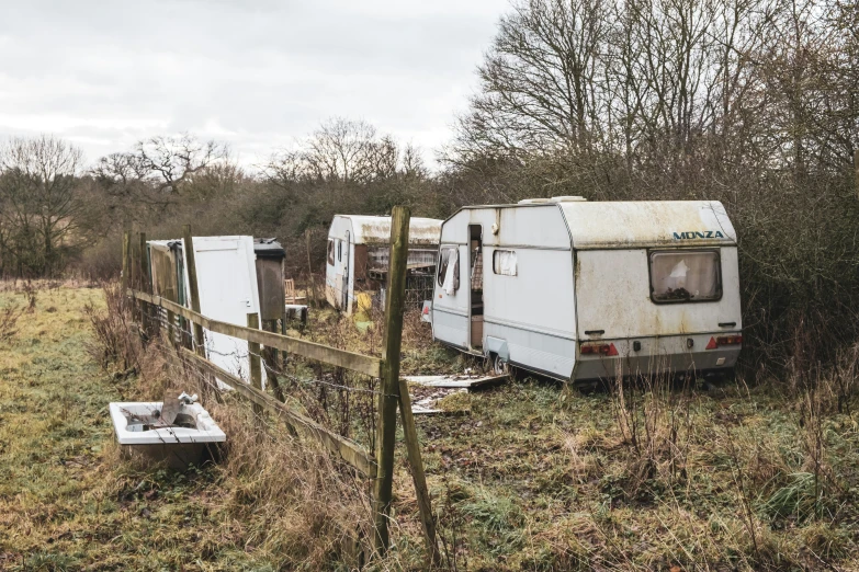 an old trailer sitting outside in a field