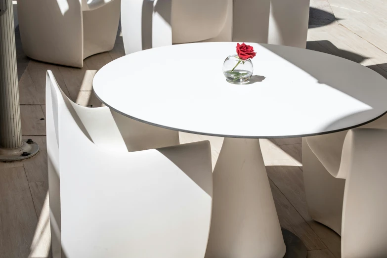 a white round dining table and white chairs