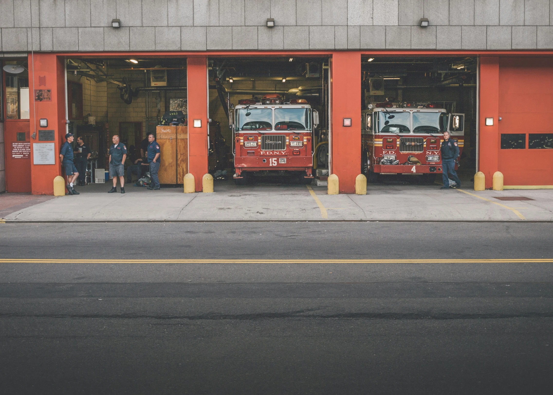 firetrucks are parked outside of an industrial building on the street