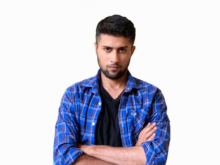 a man standing in a plaid shirt and arms folded