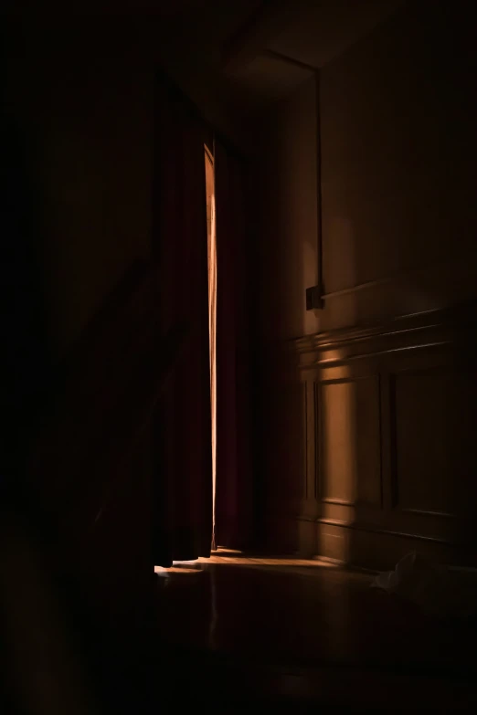 a dark room with light shining through the window