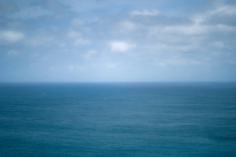 an ocean filled with a boat next to a large body of water