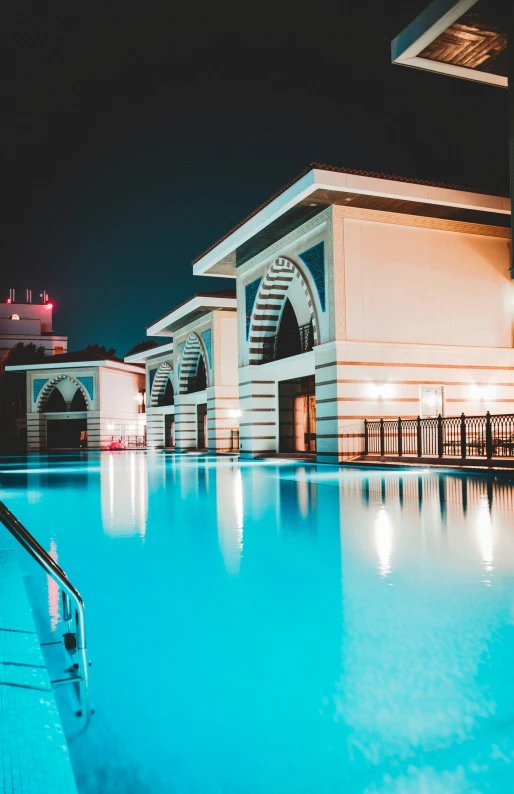 the pool at night is empty with its lights on