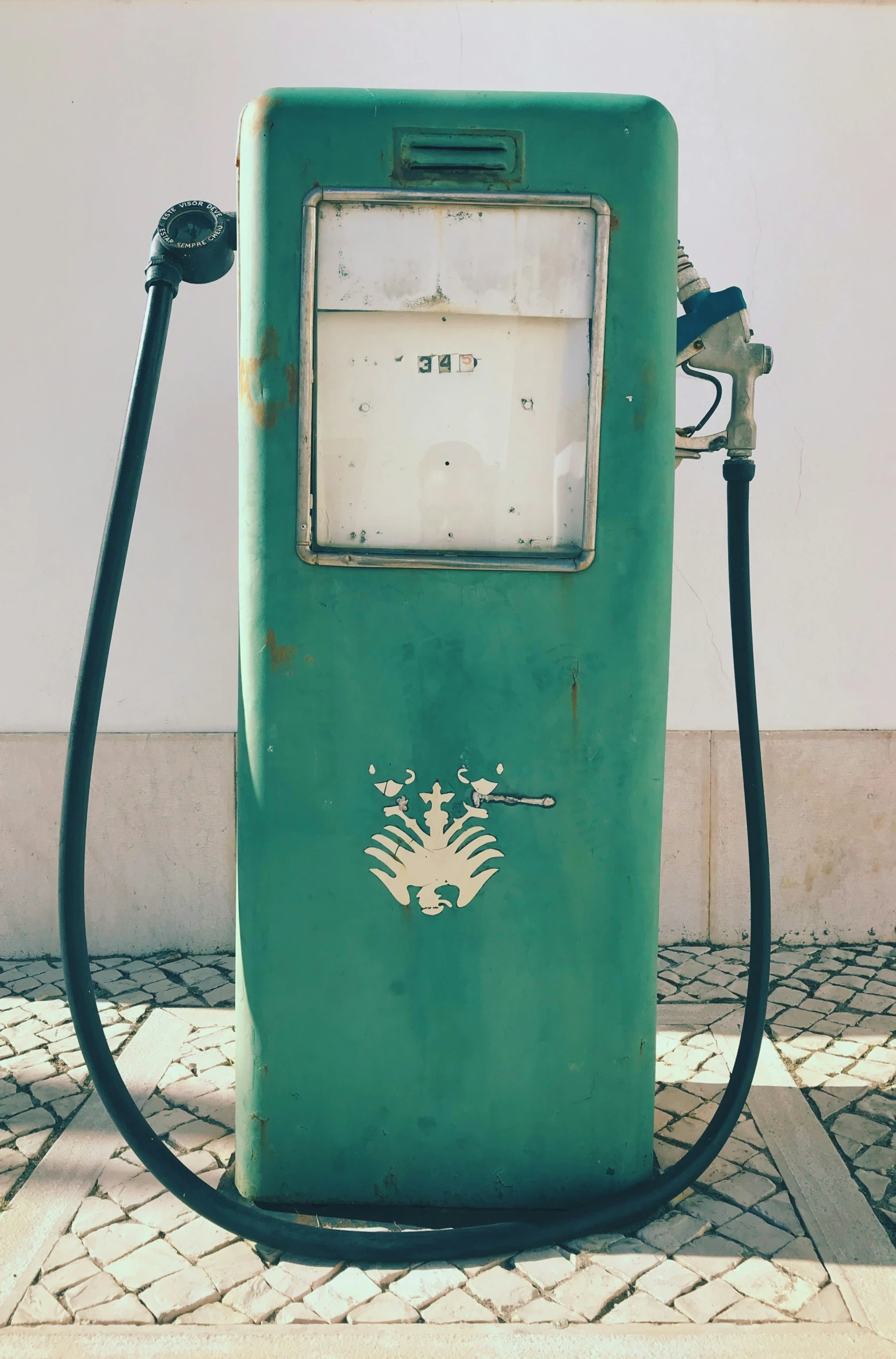 there is a green gas pump on the sidewalk