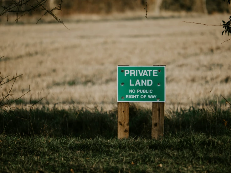 a sign in the middle of the grassy field