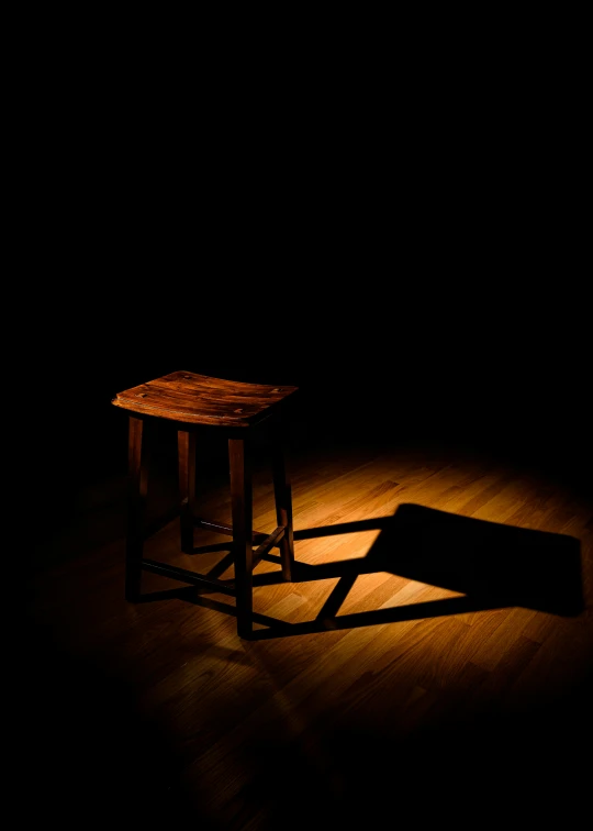 a wooden stool and foot rest in a dark room