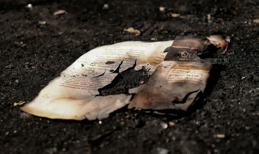 an open newspaper with torn off pages laying on the ground